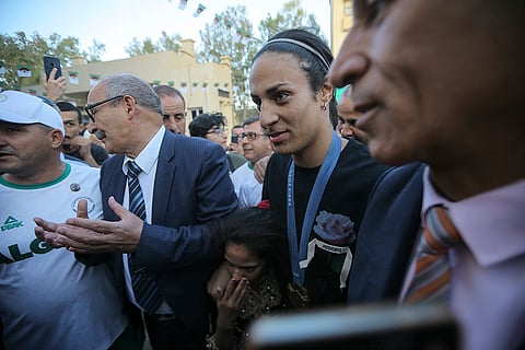 Algeria's boxer Imane Khelif smiles as she arrives home